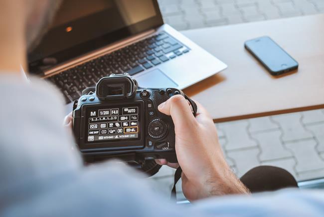 Mężczyzna przeglądający ustawienia aparatu fotograficznego