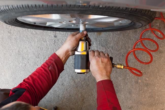 Mechanik odkręcający koło w samochodzie
